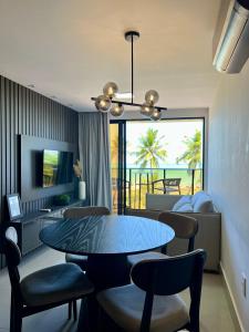 comedor con mesa y sillas y sala de estar en Frente Mar Apartamento Luxuoso na praia de Cabo Branco, en João Pessoa
