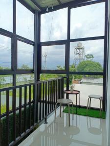 a room with two chairs and a table and windows at Orange house Villa in Dau