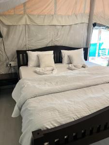 two beds with white sheets and pillows in a tent at Ales & Juli in Morjim