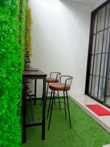 2 sillas y una mesa con una pared verde en Orange house Villa, en Dau