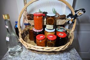 a basket filled with jars of preserves on a table at Oplenacki smestaj Milica in Topola