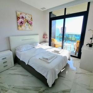 a bedroom with a large bed and a large window at Sunset Drive Apartments in Benidorm