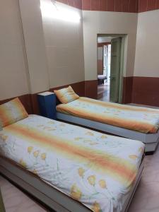 two beds are sitting in a room with a mirror at Ram Nivas Home Stay Dwarka in Dwarka