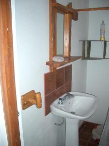 y baño con lavabo blanco y espejo. en Cabañas Gesell en Villa Gesell