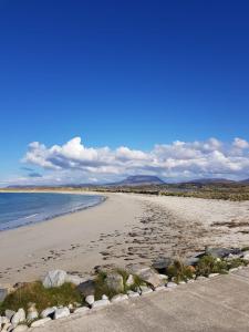 a beach with rocks and the ocean on a sunny day at Noirin's Holiday Homes in Falcarragh