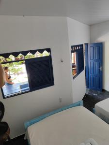 1 dormitorio con 2 camas y ventana en Hospedaria Arte Sagrada, en Canguaretama