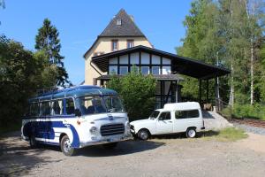 two old buses parked in front of a house at Museumsbahnhof Ahütte in Üxheim