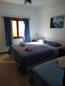 1 dormitorio con 2 camas y ventana en Hotel Maracas en Villa Gesell