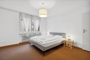 um quarto branco com uma cama e uma janela em Neumünsterstrasse 26 em Zürich
