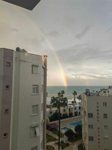 un arco iris sobre el océano con edificios y una ciudad en Sahil One bedroom Apartment, en Mezitli