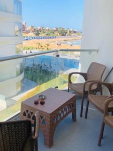 a balcony with a table and chairs and a view of a pool at Scandic beach resort in Hurghada