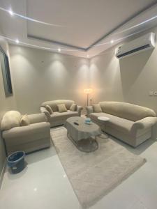 ein Wohnzimmer mit 2 Sofas und einem Tisch in der Unterkunft غرفتين بدخول ذاتي in Al Kharj