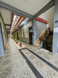 an empty hallway with a tile floor and stairs at pondok Syariah Hadikusuma 