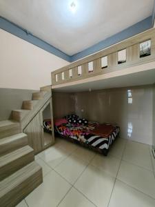 een slaapkamer met een stapelbed en een trap bij pondok Syariah Hadikusuma 