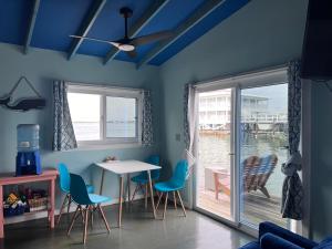 a dining room with a table and chairs and a window at Dockside Utila Ocean front suites in Utila