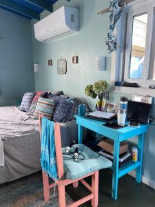 a bedroom with a blue desk and a bed with a laptop at Dockside Utila Ocean front suites in Utila