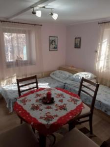 a room with two beds and a table and chairs at Lovely studio in Dragoman with garden and garage in Dragoman