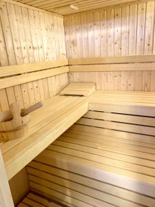 uma sauna de madeira vazia com pisos e tectos de madeira em Domek Monte Black z jacuzzi i sauną fińską em Stronie Śląskie