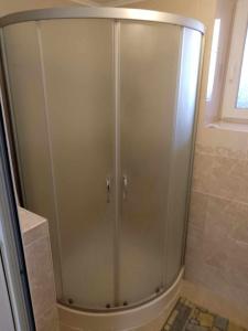 a shower with a glass door in a bathroom at Lovely studio in Dragoman with garden and garage in Dragoman