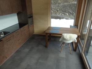 eine kleine Küche mit einem Tisch und einem Stuhl in der Unterkunft Bätzenboden Stöckli 1375A in Wengen