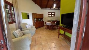 uma sala de estar com televisão e uma sala de jantar em Casa Vista Panorâmica em Florianópolis