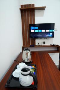 un tavolo con un vassoio con piatti e una TV di UNIVERSAL RESIDENCY a Perumpāvūr Altre 9 foto