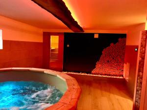 a large bath tub in a room with a tv at Domek Monte Black z jacuzzi i sauną fińską in Stronie Śląskie