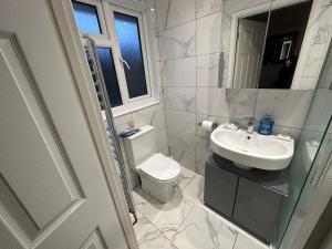 a bathroom with a toilet and a sink and a shower at Ashcroft Quiet Garden House-London Luton Airport in Luton