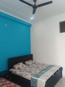 um quarto com uma cama com uma parede azul em Maa vaishno paying guest house em Ayodhya