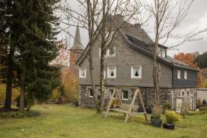 une vieille maison avec un banc devant elle dans l'établissement Alte Vikarie, à Winterberg