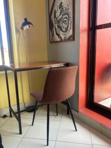 a desk with a chair and a lamp in a room at the bib By Jevas in Dar es Salaam