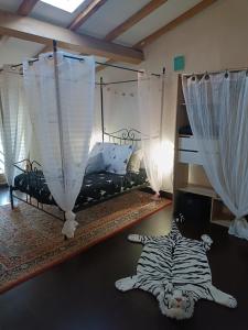 a bedroom with a bed with a zebra laying on the floor at Jolie maison de village in Capendu