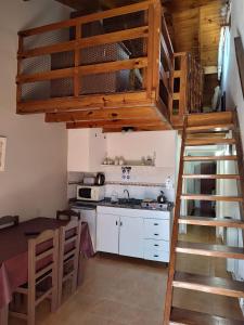eine Küche mit einem Hochbett und eine Küche mit einem Tisch in der Unterkunft Complejo Mares in San Bernardo