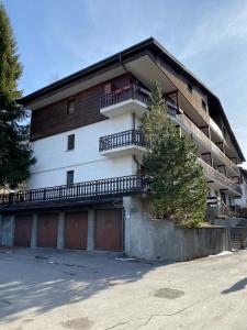 an apartment building with a balcony and a parking lot at Le Grange Apartments - Direct Ski Access in Sauze dʼOulx