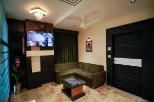 a living room with a couch and a flat screen tv at Hotel Suncity in Ahmedabad