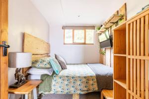 1 dormitorio pequeño con 1 cama y TV en Mountain View Lodge, en Ludlow