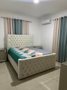 a bedroom with a bed in a room with curtains at Apartamento Amueblado en Bonao in Bonao
