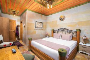 a bedroom with a bed and a wooden ceiling at Katapa Stone House in Goreme