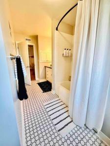baño con ducha con cortina blanca en Spacious 2 Bedroom Home w/ Yard, en Chico
