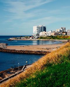 a view of a beach with a city in the background at Hostel Playa Grande Güemes in Mar del Plata