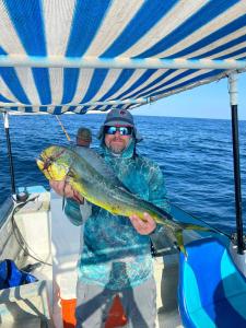 a man on a boat holding a large fish at Hotel- Whale Tours and Sport fishing Vista Mag-Bay in San Carlos