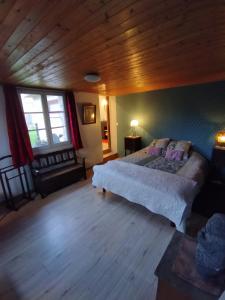 1 dormitorio con 1 cama grande y techo de madera en Chambres d'hôtes du chemin de la maison blanche, en West-Cappel