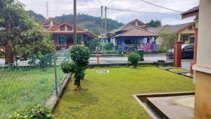 a fence in front of a yard with a tree at ZR Homestay in Jitra