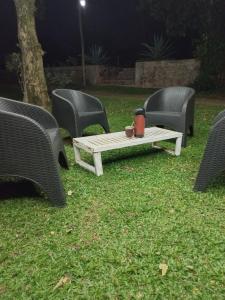 cztery krzesła i stół w trawie w nocy w obiekcie Del monte Dormis w mieście Dos de Mayo