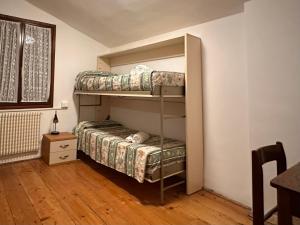 Ce dortoir comprend 2 lits superposés et une table. dans l'établissement Ostello AMDG, à Venise