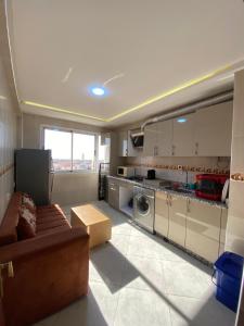 a living room with a couch and a kitchen at ELFA APPARTEMENTS Familiaux in Agadir