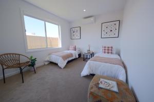 1 dormitorio con 2 camas y ventana en Modern Spacious Coastal Villa, en Ocean Grove