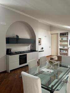 a living room with a glass table and a kitchen at CIVICO 16 in Chiaravalle