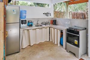 y cocina con fregadero, fogones y nevera. en Casa Baleia - Caraíva - 100m da Igreja, en Caraíva