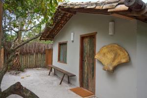 a building with a bench and a large skull on the wall at Casa Baleia - Caraíva - 100m da Igreja in Caraíva